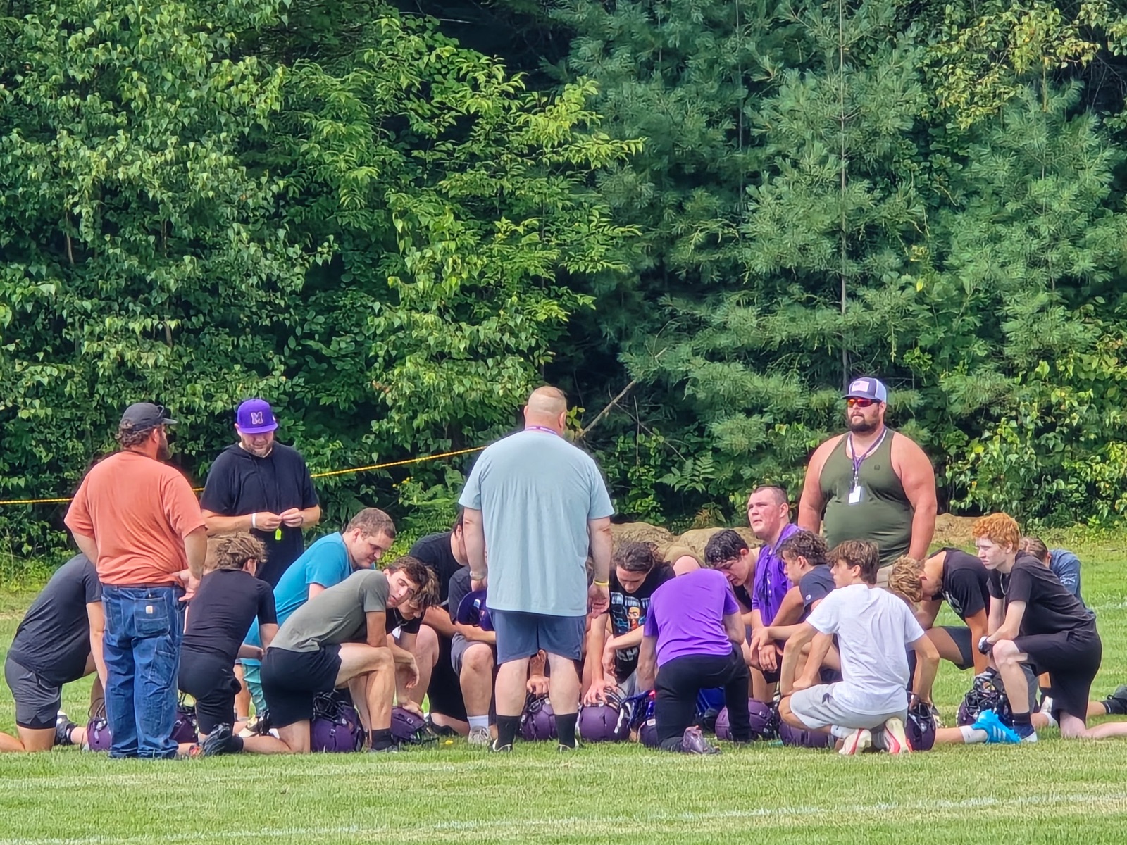 Mascoma Royals players and coaches gathered together on the football field