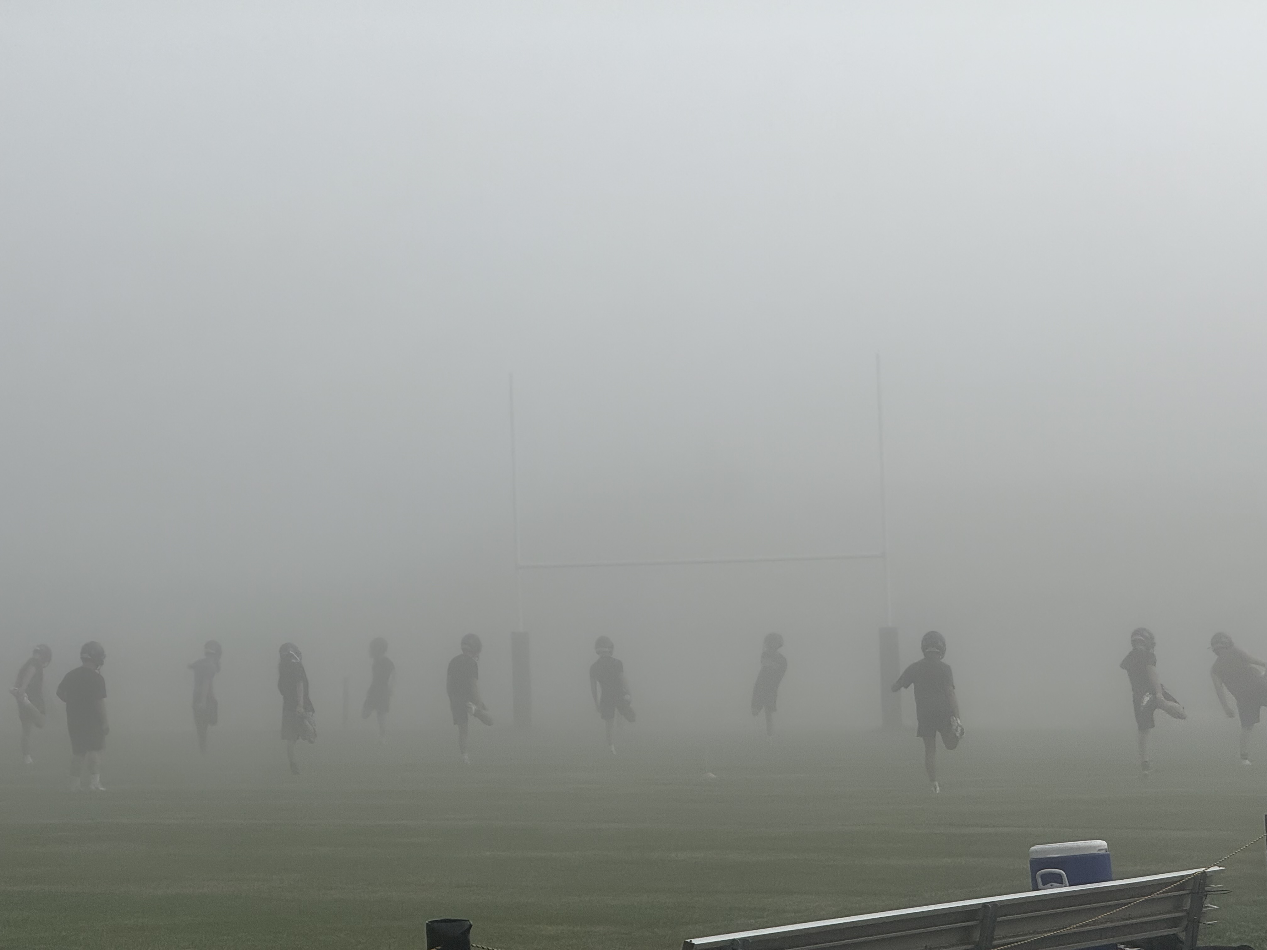 Mascoma Royals players crossing the football field during a foggy practice