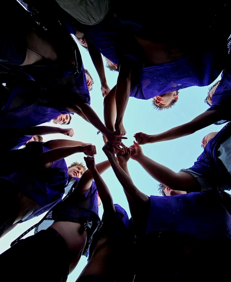 Mascoma football players huddling together with hands in at the center